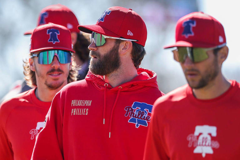 Bryce Harper, center, next to Bryson Stott and Trea Turner during spring training, enters Year 6 as a Phillie.