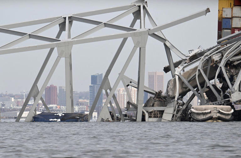 The steel frame of the Francis Scott Key Bridge and a container are partially submerged in the water after the bridge collapsed in Baltimore, Maryland on March 26, 2024.