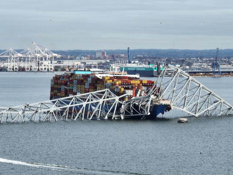 In this aerial image, the steel frame of the Francis Scott Key Bridge sits on top of a container ship after the bridge collapsed, Baltimore, March 26, 2024.