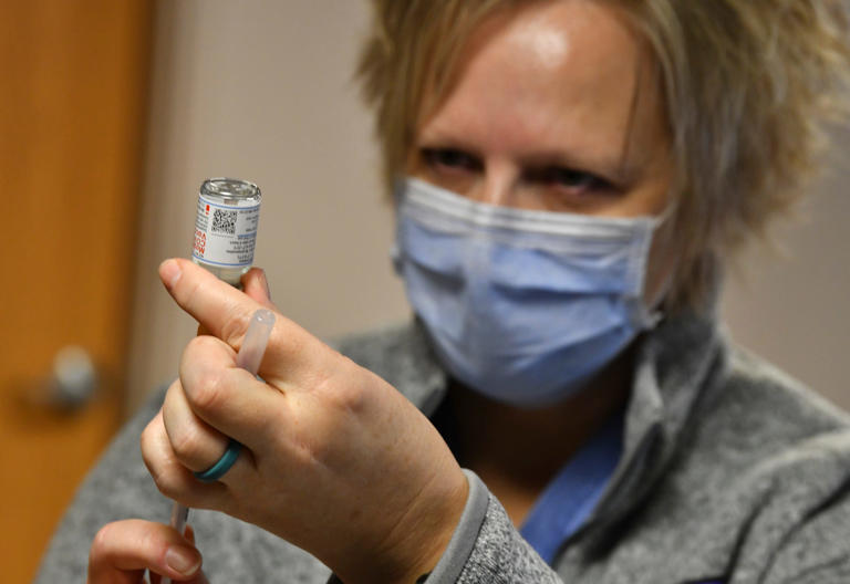 RN Shelly Hemmesch prepares a dose of Modern COVID-19 vaccine before the start of a CentraCare mobile strike team clinic Wednesday, Feb. 10, 2021, at the Salvation Army center in St. Cloud.