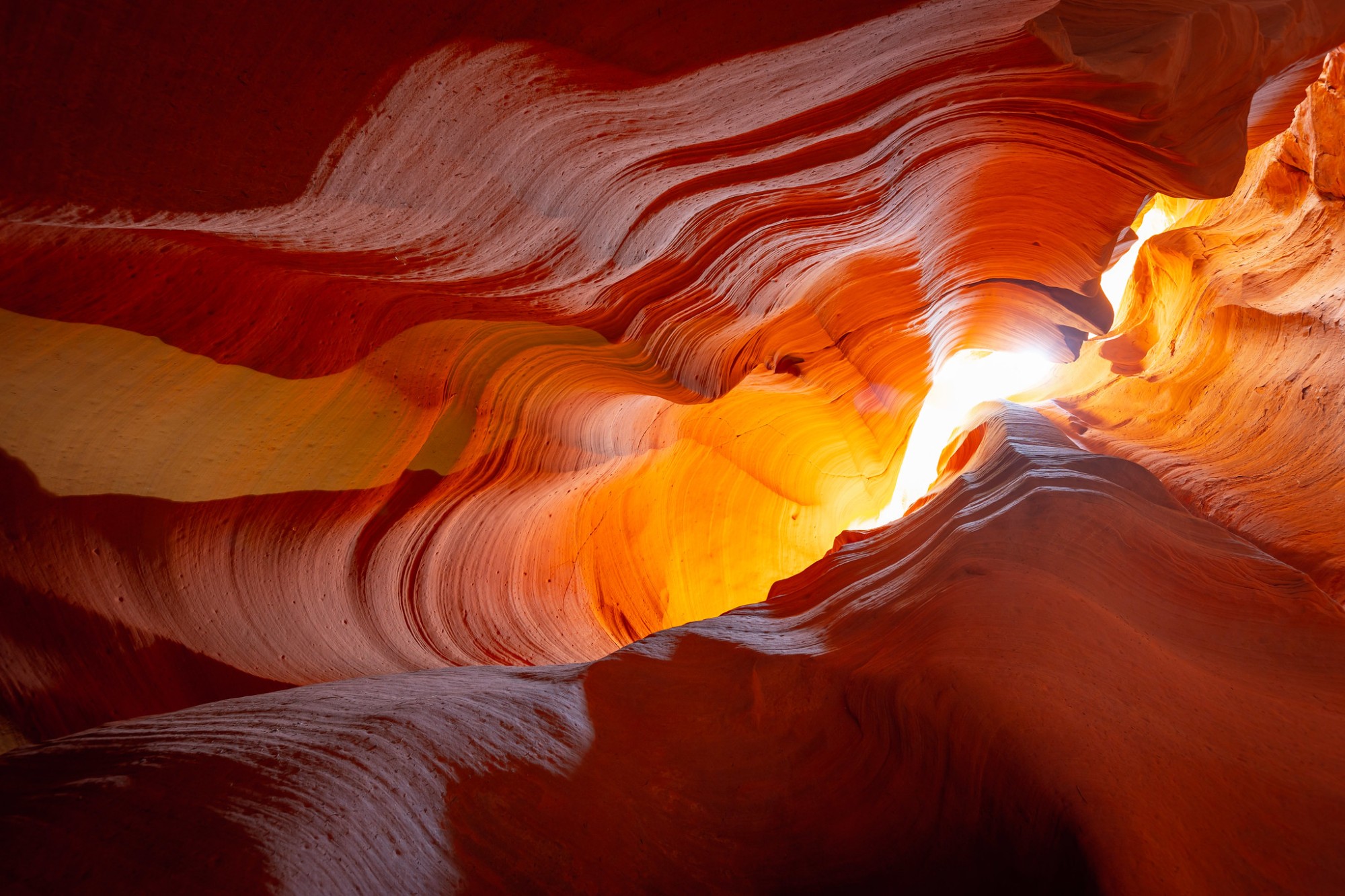 Antelope Canyon owes its creation to millions of years of erosion caused by flash floods and other natural processes. Rainwater, particularly during the monsoon season, rushes through the narrow passageways, gradually carving out the intricate shapes and contours that define the canyon's interior. Over time, these passageways have deepened and smoothed, resulting in the iconic "flowing" formations that characterize the canyon today.