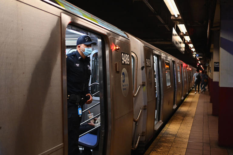 A New York Police Department officer looks out of a subway car in New York City on April 13, 2022, one day after people were injured during a rush-hour shooting in the Brooklyn borough of New York City.