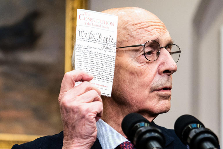 Then-Supreme Court Justice Stephen Breyer holds up a copy of the Constitution during the announcement of his retirement at the White House on Jan. 27, 2022.
