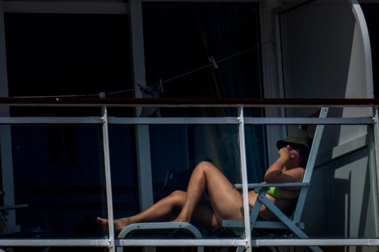 A passenger is photographed on the cruise ship MSC Armony, moored in the port of Barcelona - AP
