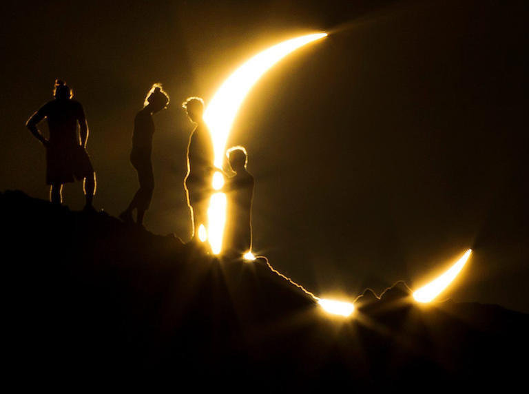 Hikers witness a partial solar eclipse from Papago Park in Phoenix on May 20, 2012.