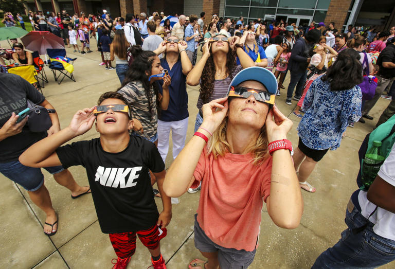 Jack Gable, left, and Andrea Tyler look toward the sky during an Eclipse 2017 Observing Event at Seminole State College on August 21, 2017. The 2024 eclipse will appear at around 59 percent of totality in Central Florida.