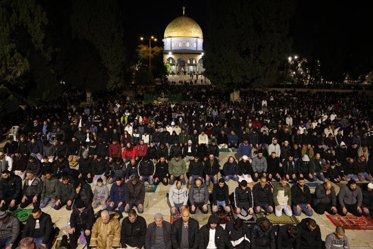 Palestinian Muslims pray outside the Dome of the Rock in Jerusalem's al-Aqsa Mosque compound on March 11, 2024. The site is the third holiest in Islam as well as the holiest for Jews, who know it as the Temple Mount. Ahmad Gharabli / AFP