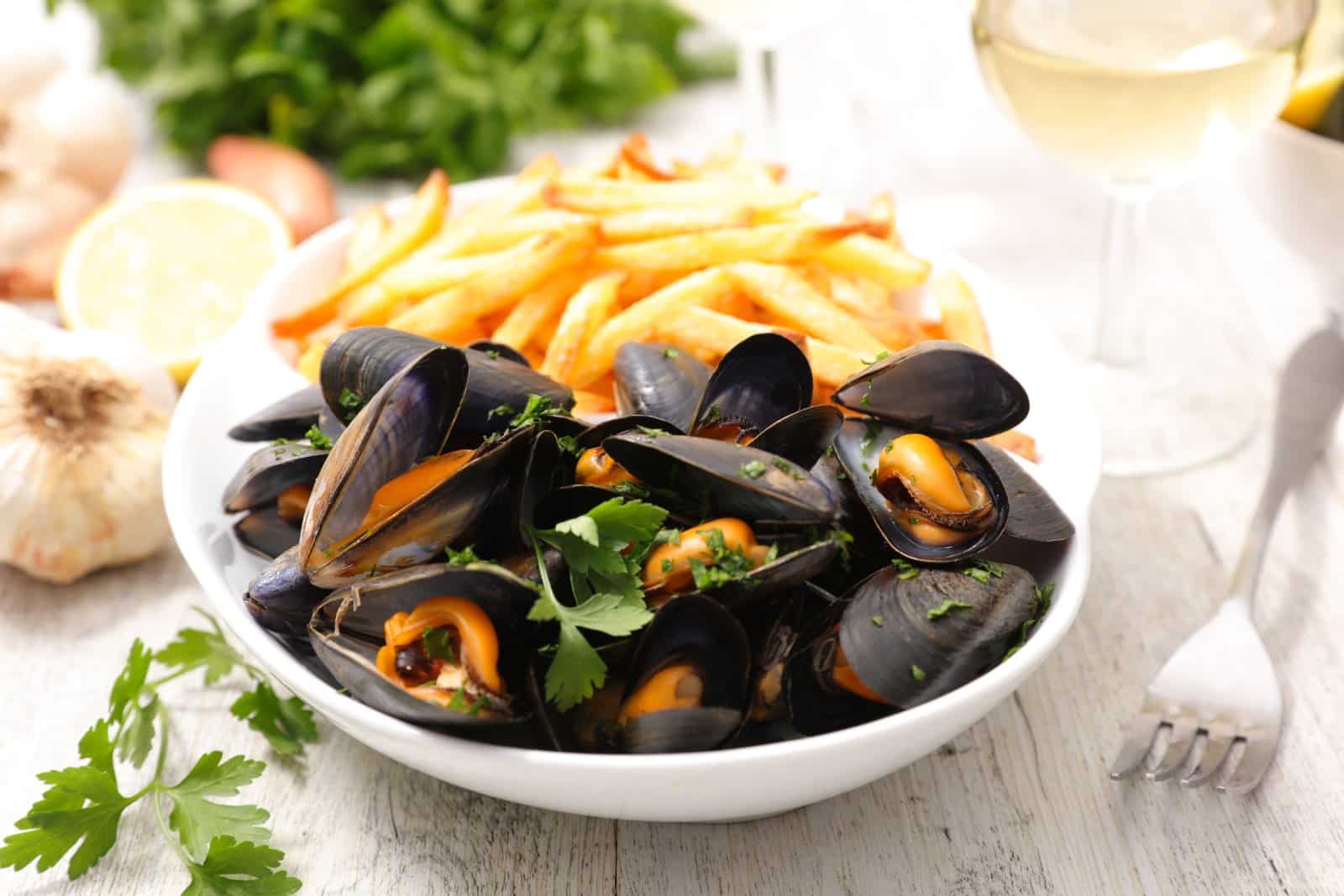 Image Credit: Shutterstock / margouillat photo <p>Steamed mussels served with a side of crispy fries, a simple yet delicious Belgian specialty.</p>