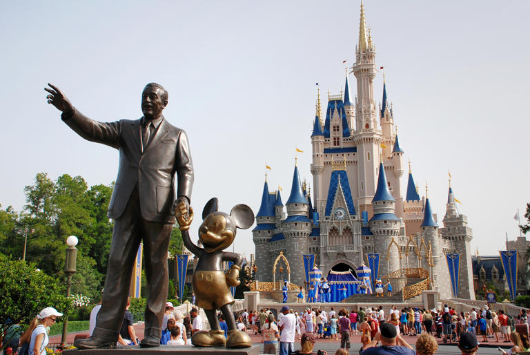 A statue of Walt Disney with Mickey Mouse outside the entrance to Cinderella's Castle at Disney World in Orlando, Fla..