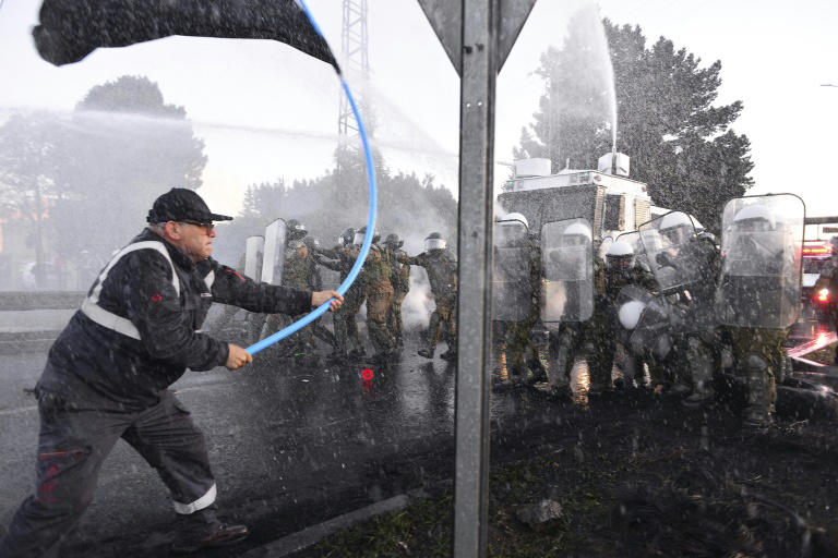 Trabajadores del acero chocan con la policía antidisturbios durante una protesta contra el eventual cierre de la planta siderúrgica de Huachipato, ubicada en la ciudad de Talcahuano, Chile, el 4 de abril de 2024