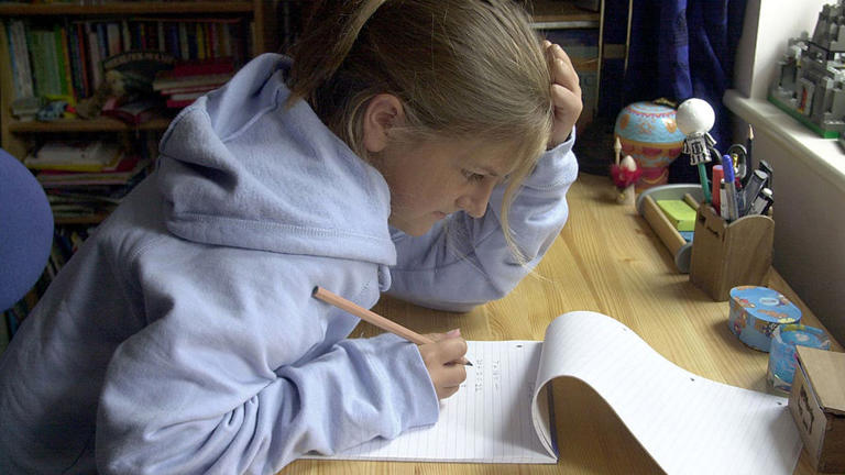 Teenage girl doing homework at desk in bedroom.. (Photo by Jeff Overs/BBC News & Current Affairs via Getty Images)