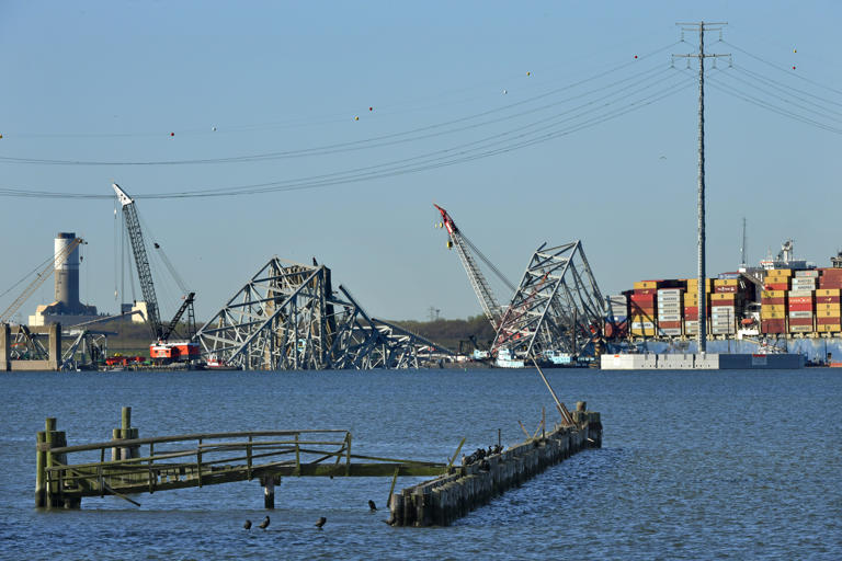 The wreckage of the Francis Scott Key Bridge rests in the Patapsco River, embedded with the container ship Dali which struck the bridge on March 26, causing the collapse which killed six workers.