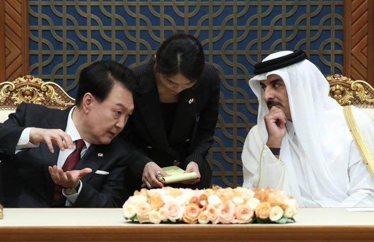 President Yoon Suk Yeol, left, speaks to Emir of Qatar Tamim bin Hamad Al Thani at Amiri Diwan in Qatar during his state visit to the country, Oct. 25, 2023. Yonhap