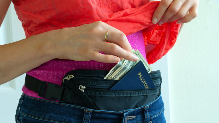 Woman getting cash and passport from hidden travel money belt