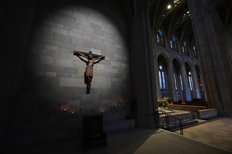 A Spanish Crucifix is illuminated as visitors pray at Grace Cathedral in San Francisco, Calif., on Friday, April 5, 2024.