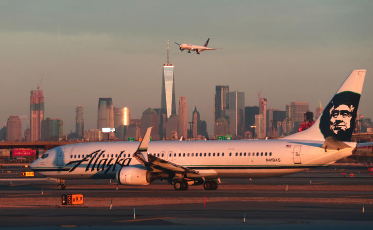 NEWARK, NJ – JANUARY 21: An Alaska Airlines airplane passes by the skyline of lower Manhattan in New York City as it heads to a gate at Newark Liberty Airport on January 21, 2019 in Newark, New Jersey. (Photo by Gary Hershorn/Getty Images)