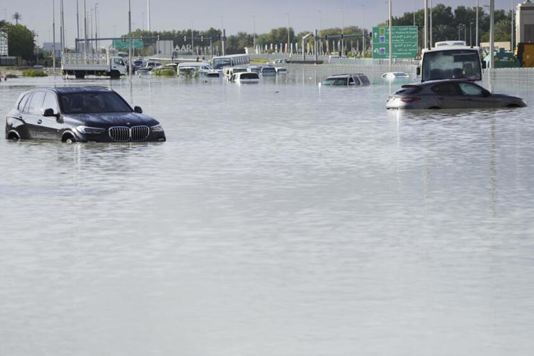 Vehicles sit abandoned in floodwaters covering a major road in Dubai on Wednesday. ((Jon Gambrell / Associated Press))