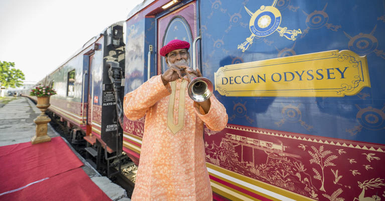 A musician plays outside the Deccan Odyssey train.