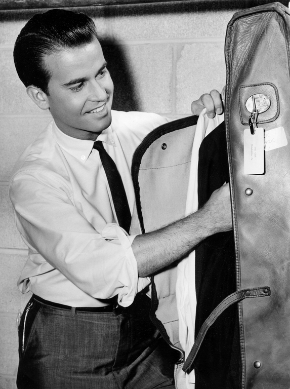 Dick Clark does his unpacking chores as he prepares for a huge show at the Municipal Auditorium on Aug. 4, 1963. Clark will emcee a 15-act, two-and-a-half hour rock and roll show before 10,000. After more than 10 years as a disc jockey, Clark made his singing debut at the show when he was called on to sing the male part of the song, \"Hey, Paula,\" as recorded by the girl-boy duo, Paul and Paula. Clark said Ray Hildebrand, \"Paul,\" of the team was unable to make the show.