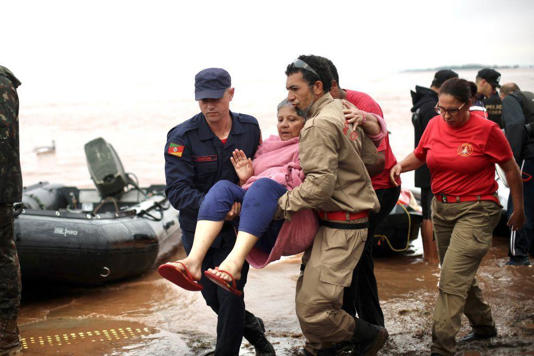 Mulher é resgatada por bombeiros durante enchentes no Sul