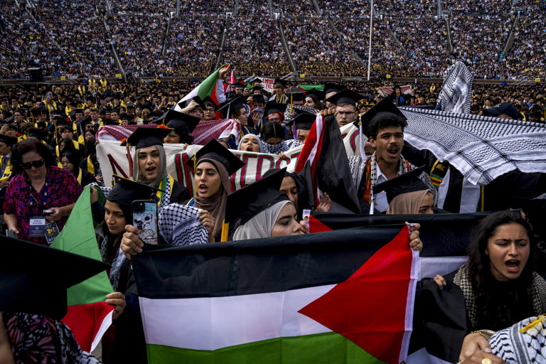 Students demonstrate during a Pro-Palestinian protest during the University of Michigan's spring commencement ceremony on May 4, 2024, at Michigan Stadium in Ann Arbor, Michigan. The protesters called for the University of Michigan to divest from companies with ties to Israel during the spring commencement ceremony.