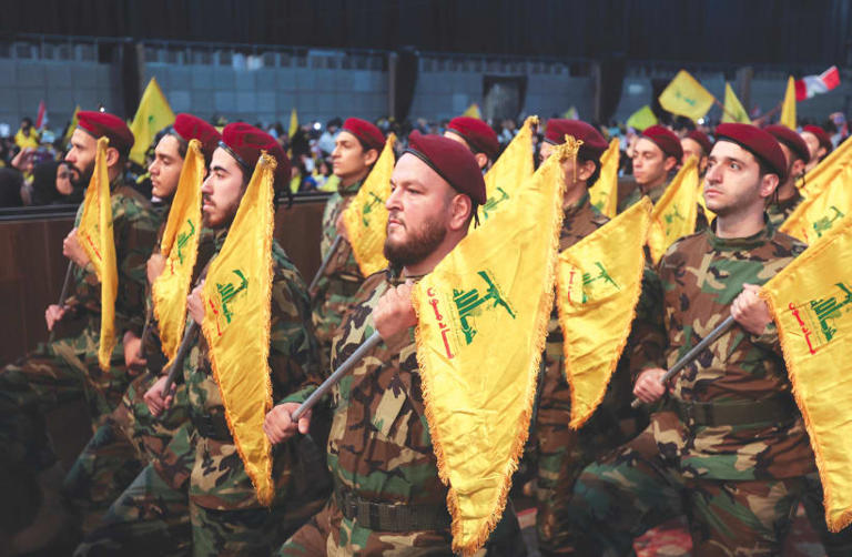  HEZBOLLAH MEMBERS hold flags during a rally marking the annual Hezbollah Martyrs’ Day, in Beirut’s southern suburbs, last month