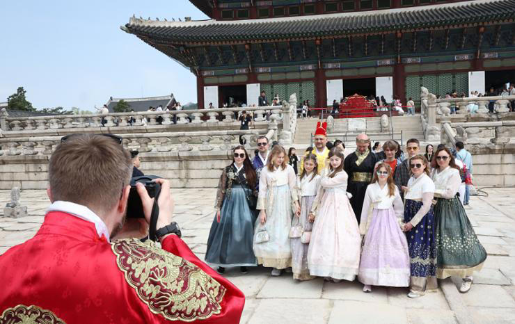 Foreign tourists wearing hanbok (traditional Korean dress) take a group photo at Gyeongbok Palace in central Seoul, Wednesday. Yonhap 