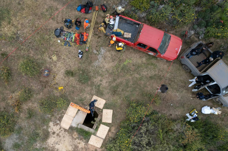 Vue aérienne de secouristes, légistes et procureurs près d'un puits où des cavadres ont été découverts, le 3 mai 2024 à Ensenada, dans le nord-ouest du Mexique