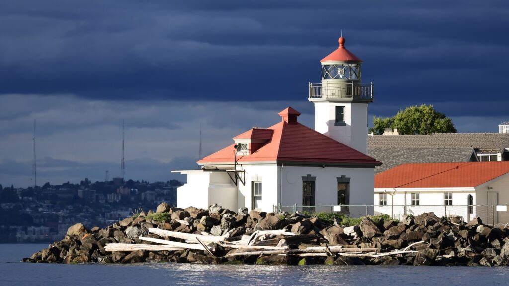 <p>The Alki Point Lighthouse, along with the nearby West Point Lighthouse, watches over Elliot Bay and provides navigational help to the frequent marine traffic coming in and out of Seattle. Originally, the only guidance for ships navigating these waters was a lantern hung on the side of a barn. In the early 1900s, the lighthouse was built and still stands in its current location.</p><p>The lighthouse is operated by the Coast Guard, which occasionally offers tours of the space.</p>