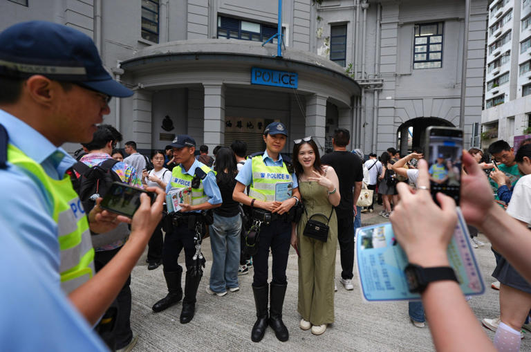 Hong Kong police officers distribute traffic safety advice and taxi service guides to mainland Chinese tourists during the golden week break. Photo: Eugene Lee