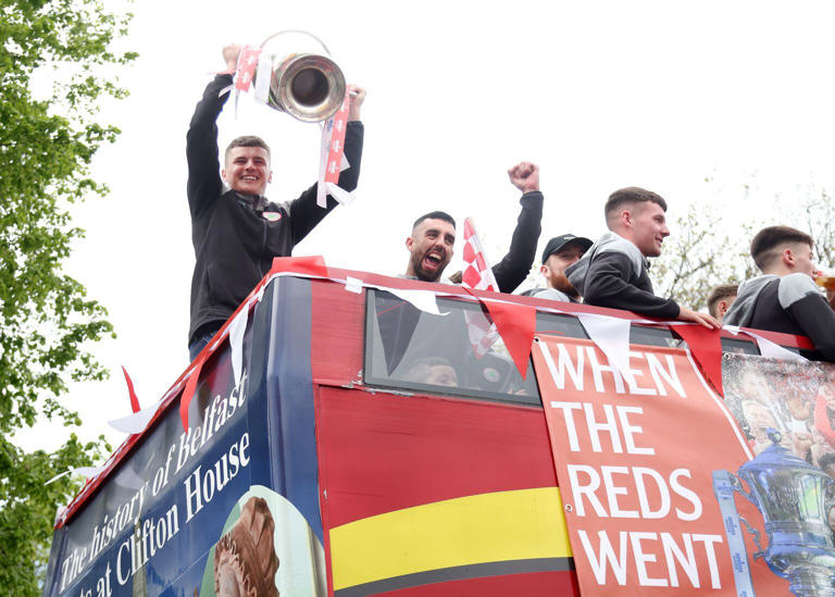 Cliftonville’s Ronan Hale and Joe Gormley celebrate with the fans during an open top bus tour across Belfast after winning the Irish Cup oat Windsor on Saturday. PIC COLM LENAGAN