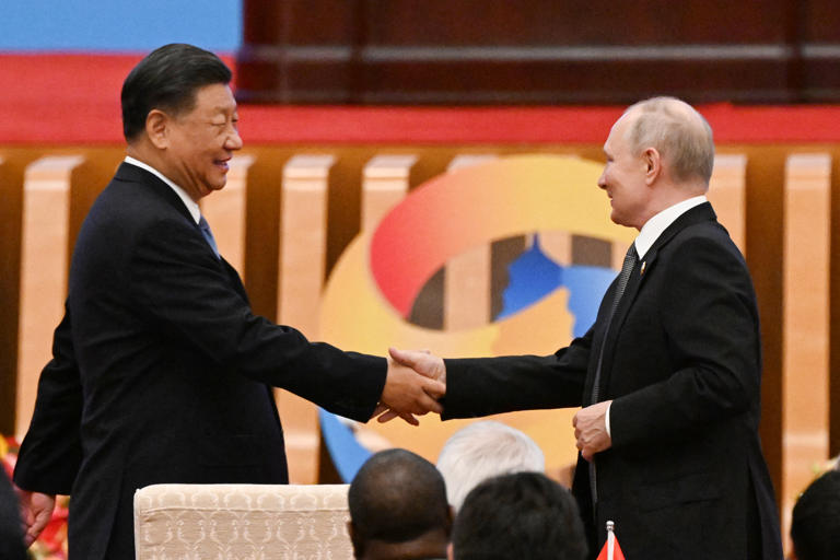 China's President Xi Jinping (L) shakes hands with Russia's President Vladimir Putin during the opening ceremony of the third Belt and Road Forum for International Cooperation at the Great Hall of the People in Beijing on October 18, 2023.