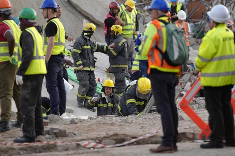 rescuers bring out survivors from the rubble a day after a deadly building collapse in south africa
