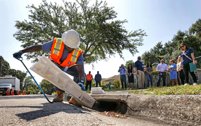 A City of Orlando worker removes debris from a storm drain on Roseboro Street in Orlando, Tuesday, May 7, 2024, as the city’s Public Works Department actively prepares for hurricane season to prevent the kind of flooding that impacted the Washington Shores neighborhood during Hurricane Ian in 2022.