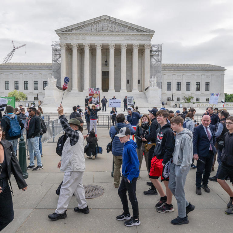 WASHINGTON, DC - APRIL 25: A tour group walks past as protestor