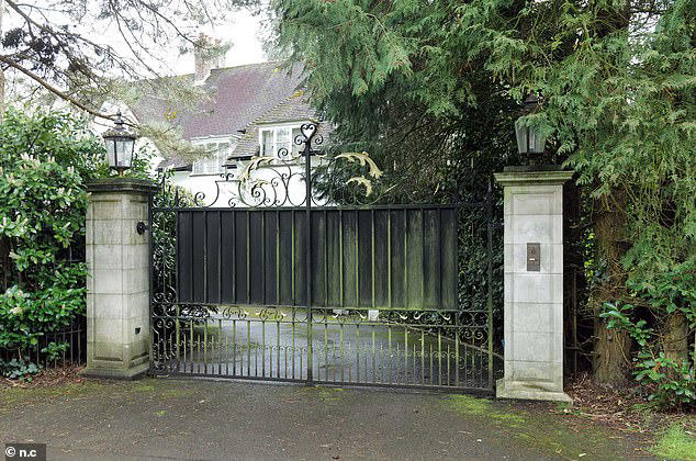 One of the imposing black gates on the estate in Surrey that has been home to the rich and famous 