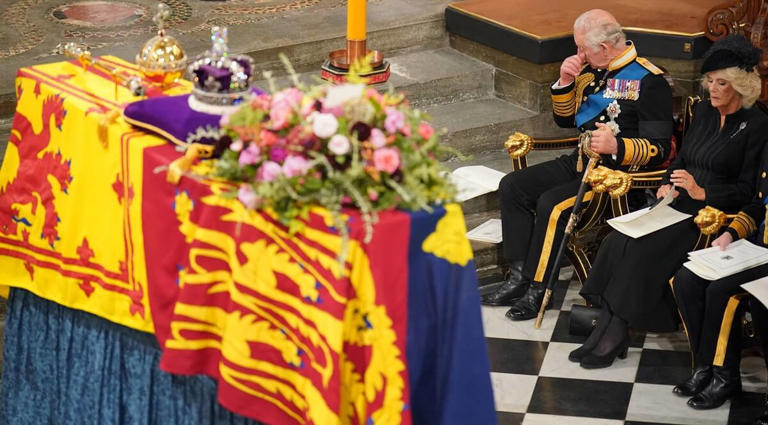 King Charles III sitting in the first pew next to his wife, Camilla, and wiping his eyes during Queen Elizabeth II’s state funeral | DOMINIC LIPINSKI/POOL/AFP via Getty Images