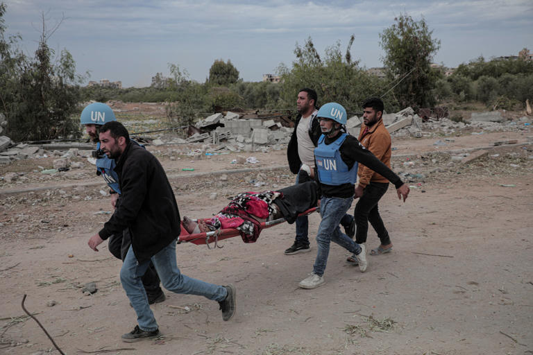 Photo of UN workers carrying an injured Palestinian on a stretcher in northern Gaza on Nov. 25