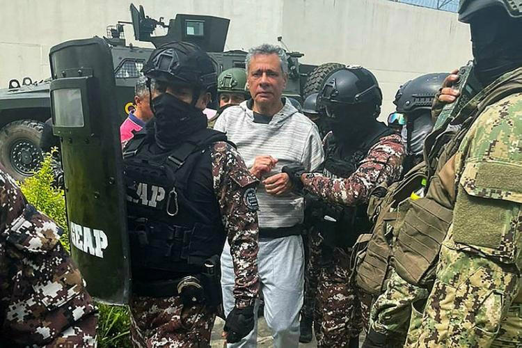 Cette photo publiée par la police équatorienne montre l’ancien vice-président équatorien Jorge Glas escorté par des membres du Groupe spécial d’action pénitentiaire (GEAP) lors de son arrivée à la prison à sécurité maximale La Roca à Guayaquil le 6 avril 2024.