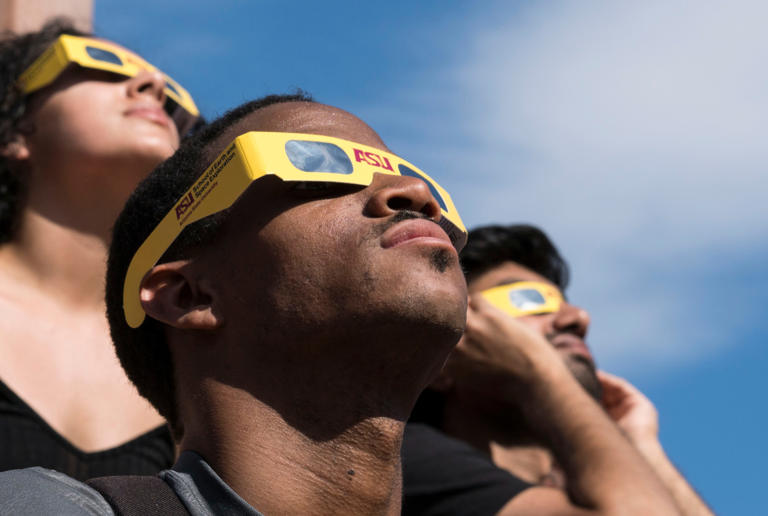 Steven Williams, in front with other ASU students, watches the solar eclipse wearing protective glasses at Hayden Lawn at ASU's Tempe campus on Aug. 21, 2017. This party was organized by ASU's School of Earth and Space Exploration.