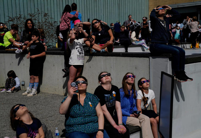 Visitors check out the solar eclipse at the Cranbrook Institute of Science in Bloomfield Hills on Monday, April 8, 2024.