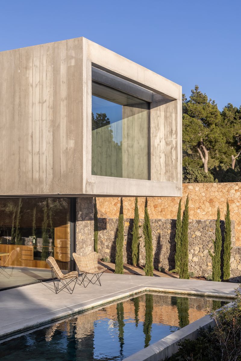 esta casa en ibiza, con piscina y patios interiores con olivos, es una oda al brutalismo y al mediterráneo