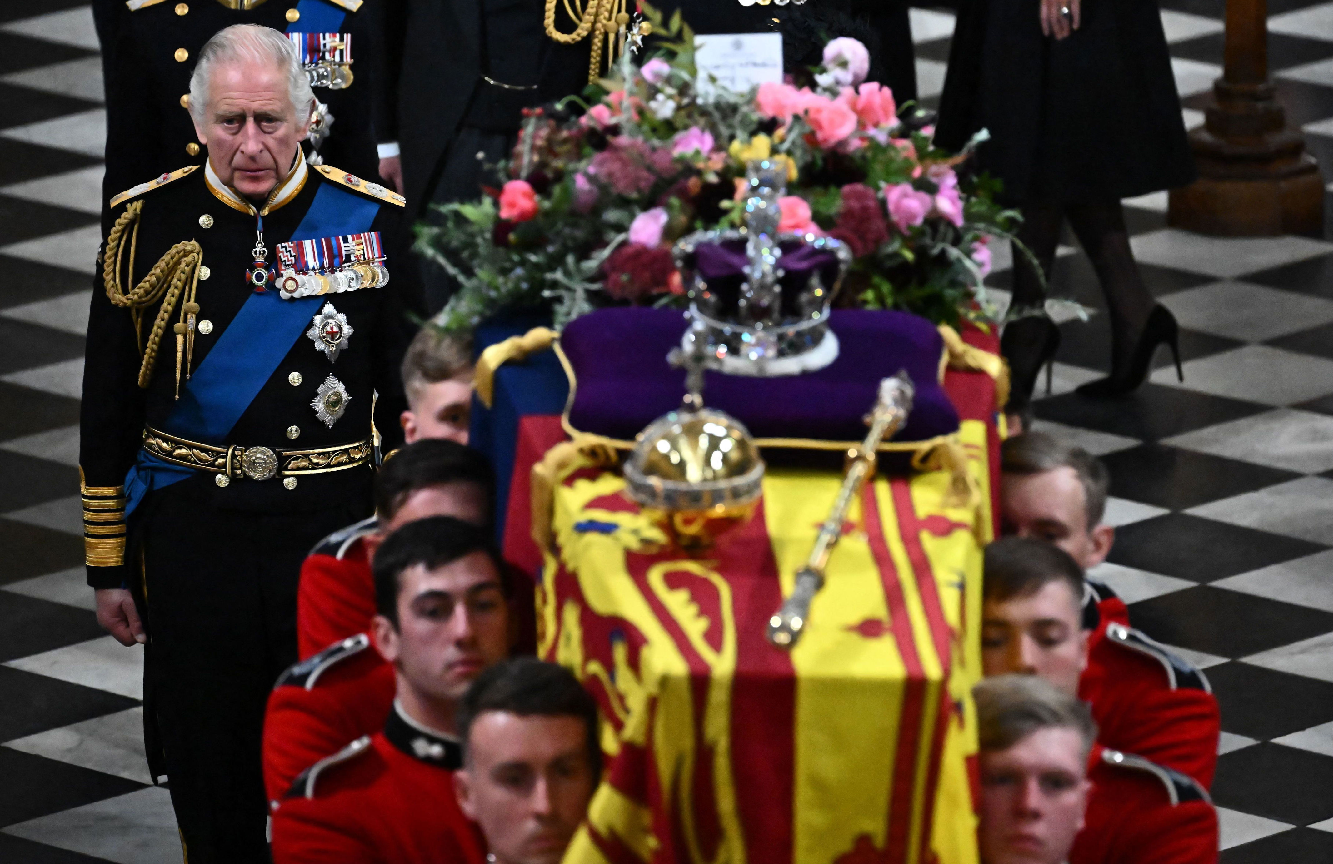 <p>Britain's King Charles III walked behind the coffin of Queen Elizabeth II as it left Westminster Abbey in London during <a href="https://www.wonderwall.com/celebrity/royals/best-photos-from-queen-elizabeth-ii-funeral-king-charles-princes-william-prince-harry-george-charlotte-kate-meghan652347.gallery">her state funeral</a> on Sept. 19, 2022. The casket was draped in the Royal Standard and adorned with the Imperial State Crown, the Sovereign's Orb and Sceptre and a floral wreath. At King Charles III's request, the wreath contained foliage of rosemary, English oak and myrtle cut from a plant grown from the myrtle in the queen's 1947 wedding bouquet plus flowers in shades of gold, pink and burgundy, with touches of white, cut from the gardens of royal residences. The card on top, written by the king, read, "In loving and devoted memory, Charles R." </p>