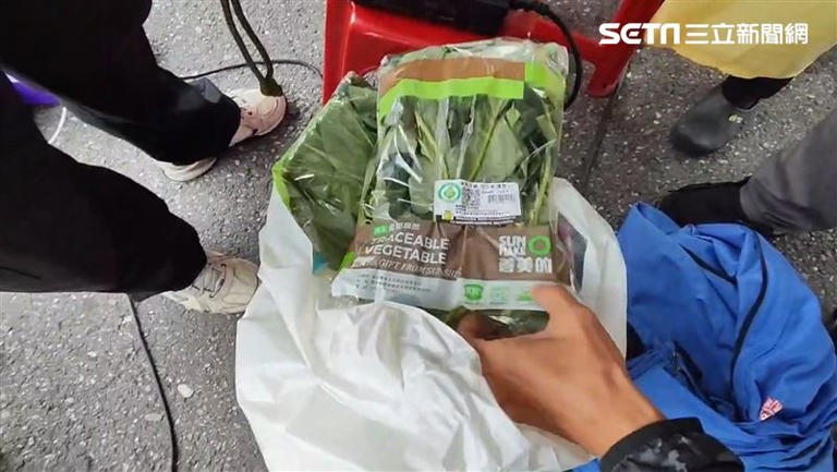 外送員提著一袋青菜抵達天王星大樓拆除現場，準備交給「收貨人」中天記者。（圖／記者呂彥攝影）