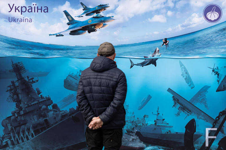 People look at a poster depicting Russian warships sunk after Ukrainian attacks in the Black Sea on March 16, 2024 in Kyiv, Ukraine. Russia's Black Sea Fleet has been badly mauled in just over two years of full-scale war.