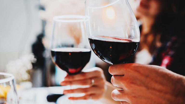 People hold glasses of red wine. Two glasses of wine - lead