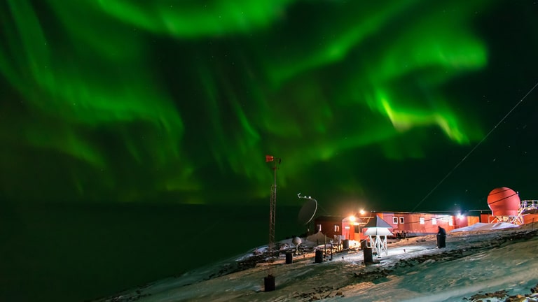 <p>Also known as the Southern Lights, the Aurora Australis is a spectacular natural light show resulting from the interaction between the Earth’s magnetic field and charged particles from the sun. This mesmerizing display of swirling green and pink lights is best viewed from the Antarctic coast, offering a magical perspective on the natural wonders beyond the cold.</p>