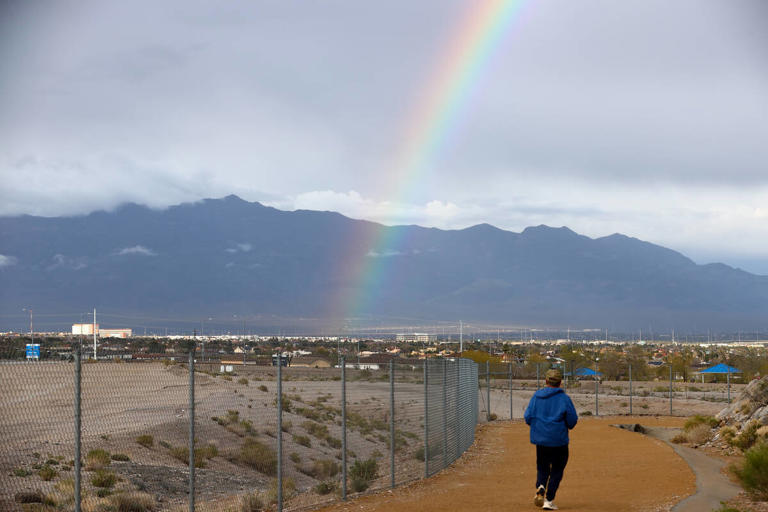 An 80-degree reading will be reached no later than Thursday, April 11, according to the National Weather Service A runner makes way around Lone Mountain under a rainbow as rain showers the Las Vegas Valley on Friday, March 15, 2024. (Ellen Schmidt/Las Vegas Review-Journal) @ellenschmidttt