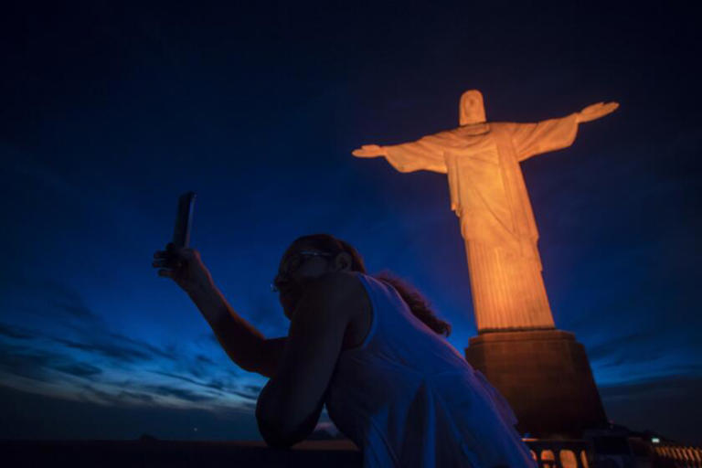 A tourist takes a selfie with the Christ the Redeemer statue in Rio de Janeiro. ((Bruna Prado / Associated Press))