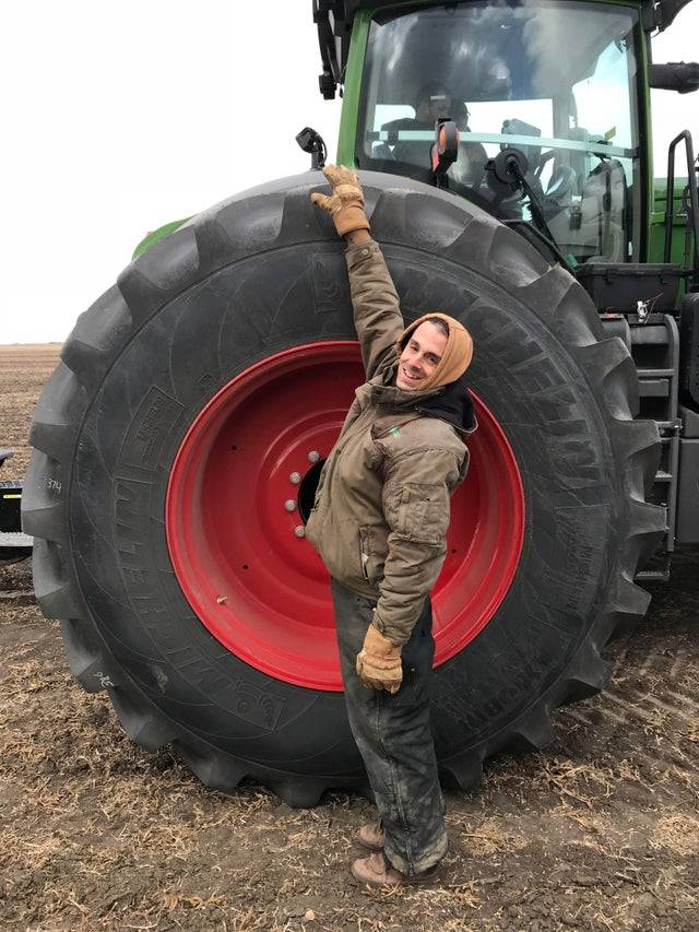 <p>A guy stood next to a Fendt 1046 rear tire, and this picture is the result. The guy is around 5'9, so it's safe to say that these wheels are huge. </p> <p>I have never been up close to a tractor, so I'm surprised that the wheels are this tall. </p>